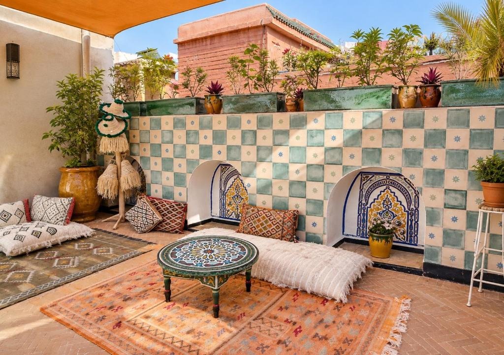Rooftop lounge with zellige tiles, Berber cushions and a painted table, Riad Hna Ben Saleh, Marrakech