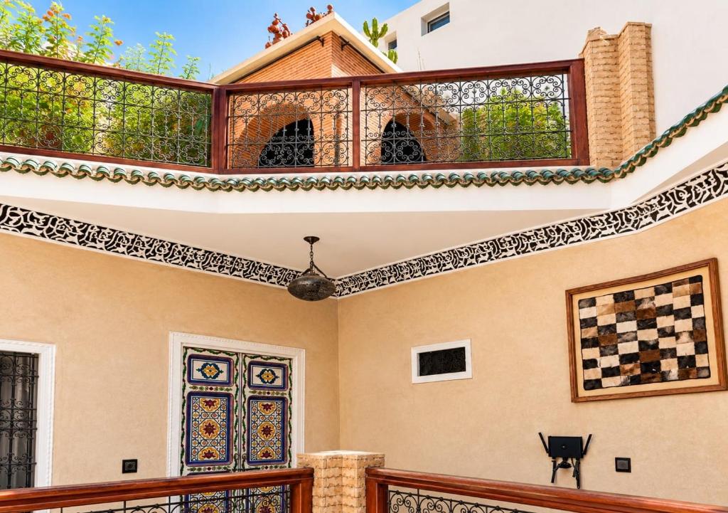 Upper gallery with wrought-iron railing and hand-painted door at Riad Hna Ben Saleh in Marrakech